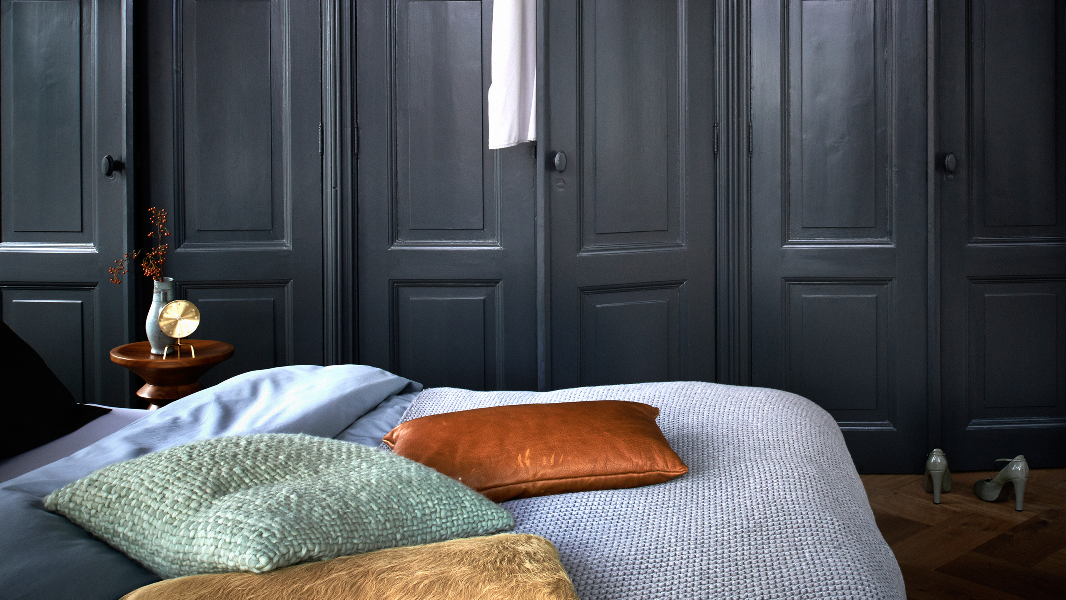 Une chambre bleu foncé Les décorateurs audacieux peuvent choisir des couleurs neutres plus sombres pour créer une ambiance intense, mais cosy dans la chambre.